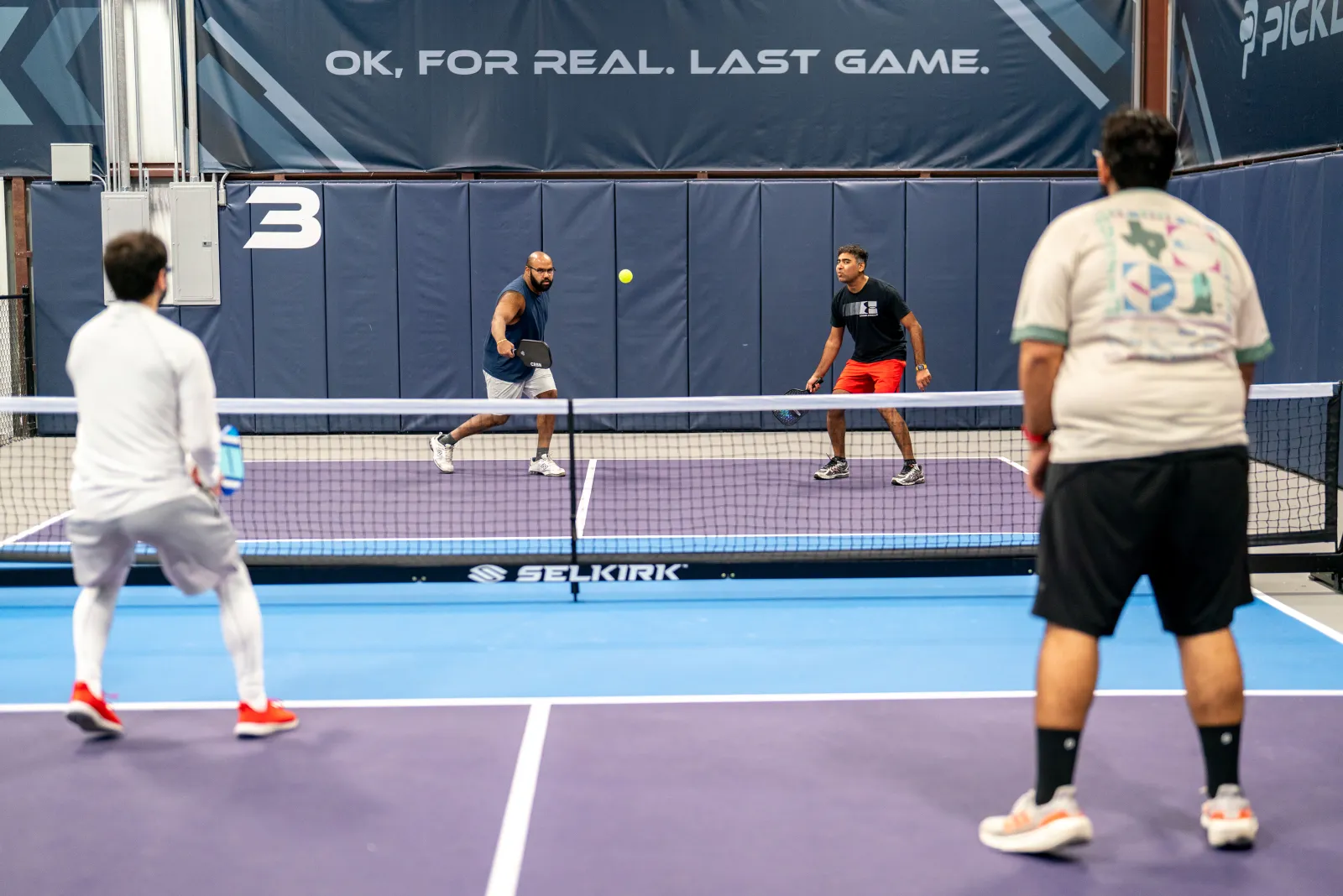 Players in a doubles rally during Desi Nights at Pickleland