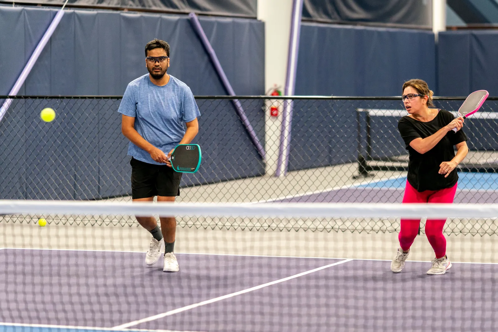 Mixed doubles partners at the net during a Pickleland social