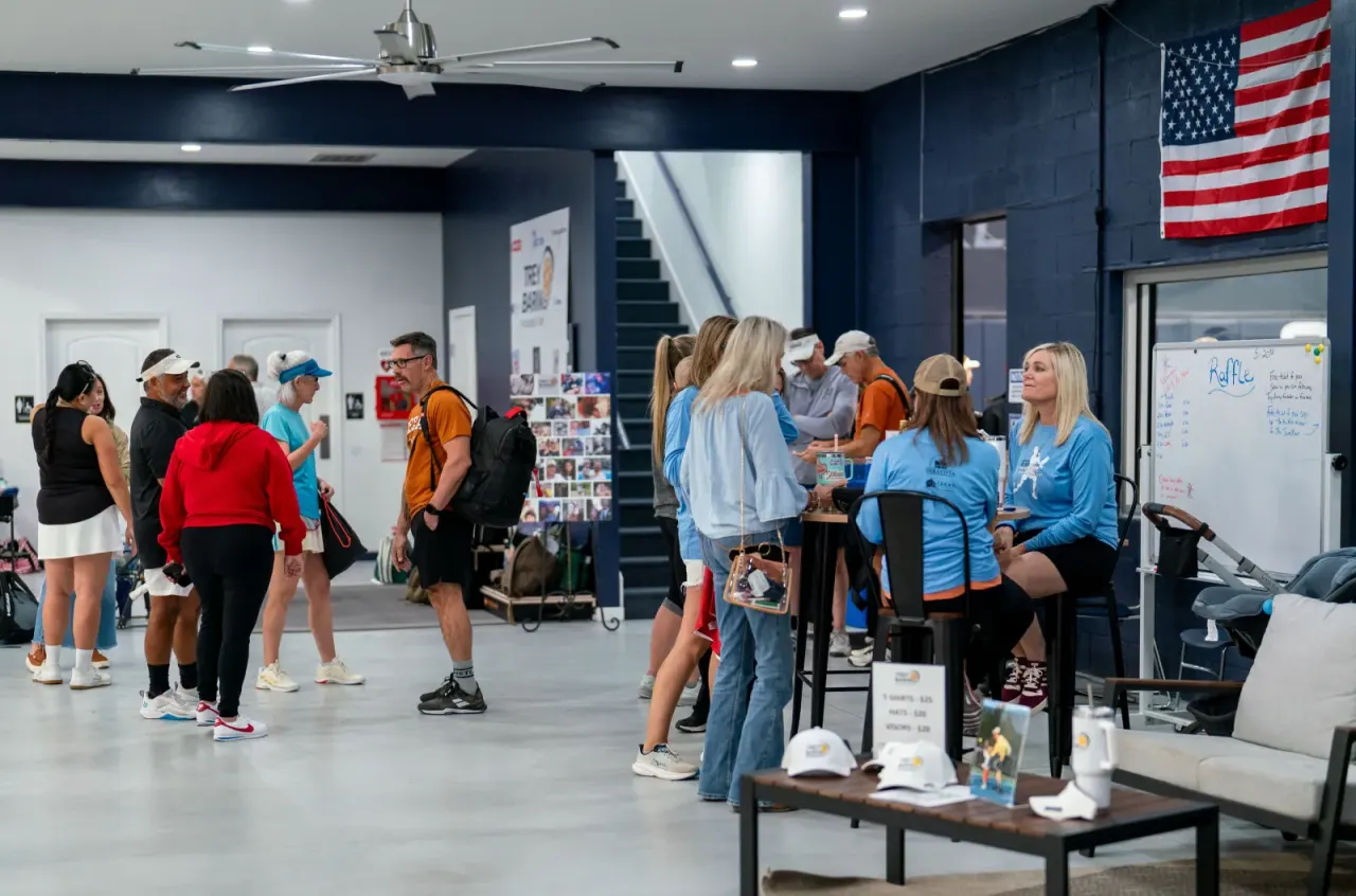 A group mingling at an indoor event at Pickleland