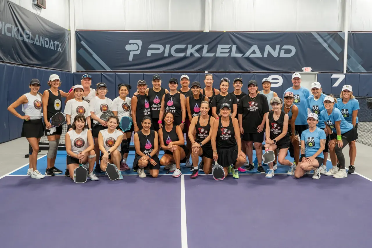 The Pickleland team and community smiling together on court in Pflugerville