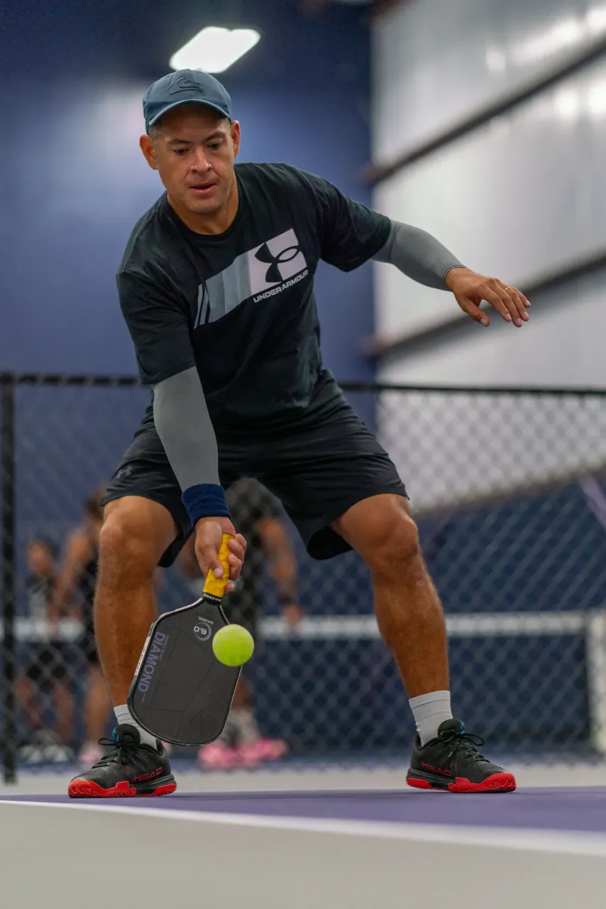 Athletic man dinks low at the net