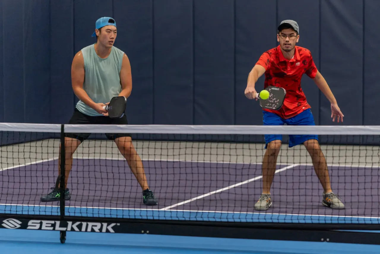 High-level men's doubles action at the net on a Pickleland court