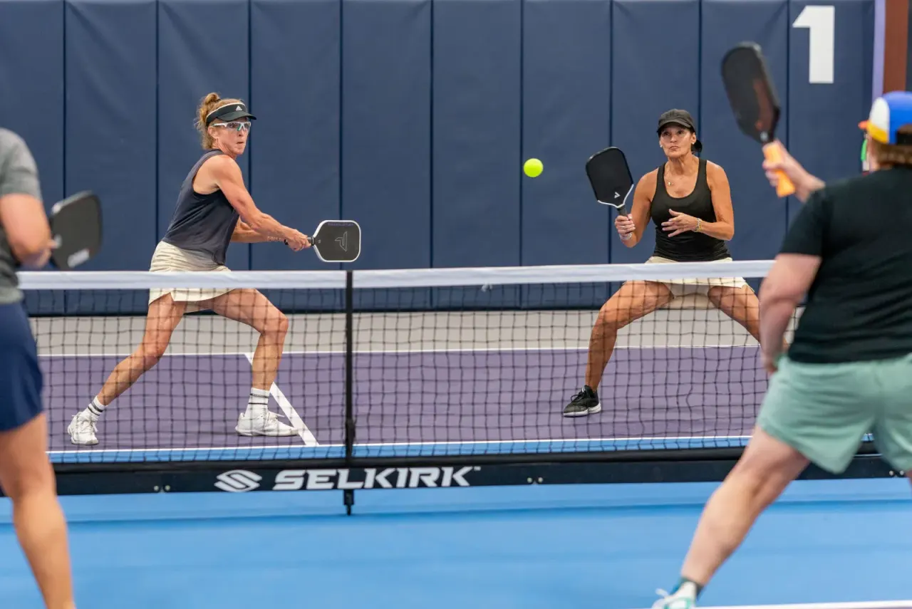 Aggressive net play during mixed doubles on a Pickleland court