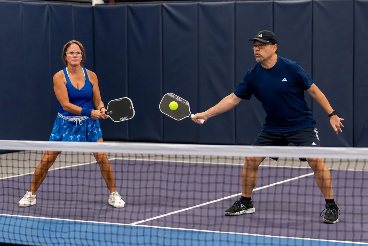 Players communicating during net play in a doubles pickleball match