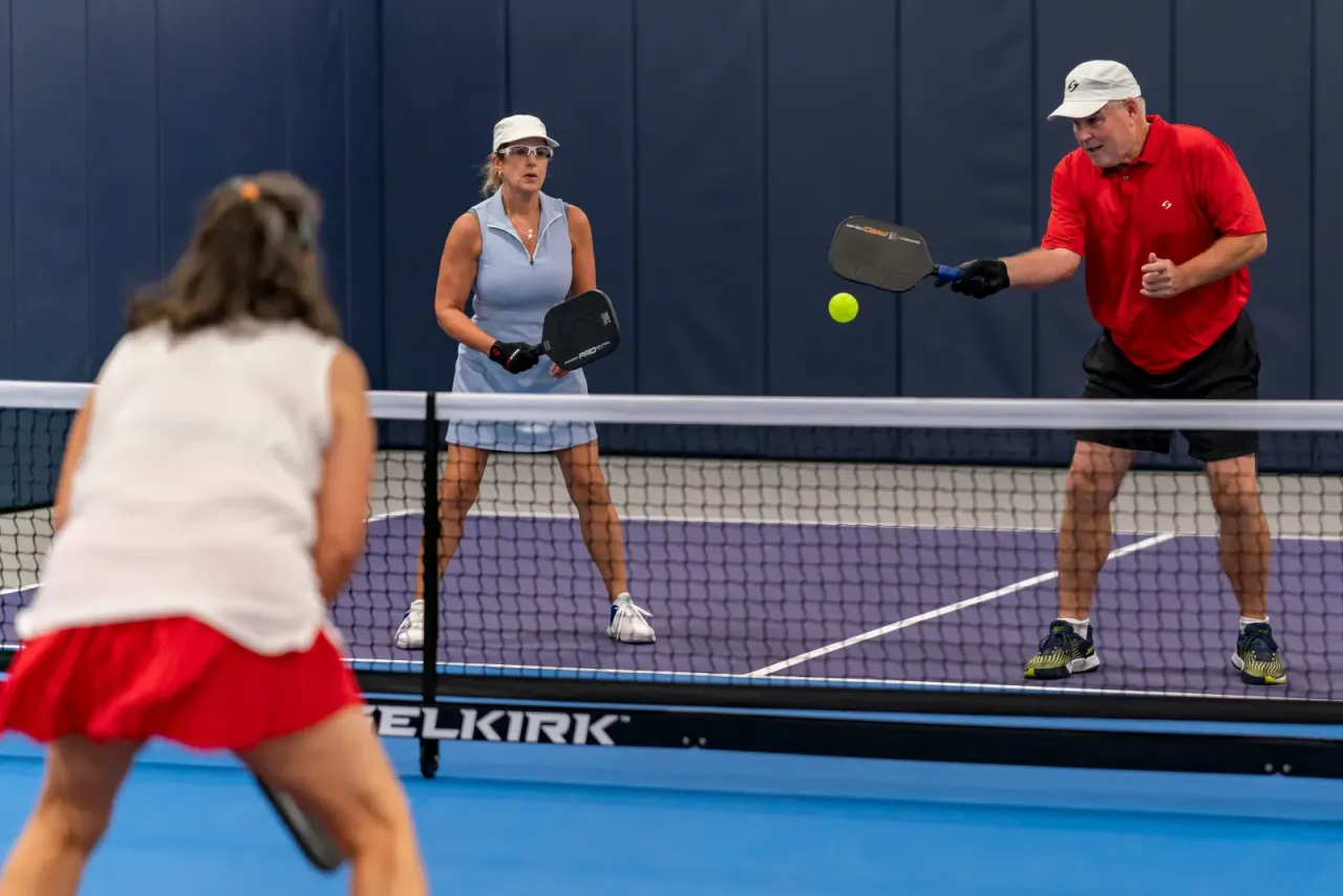 Mixed doubles pair playing at the net during a Pickleland tournament