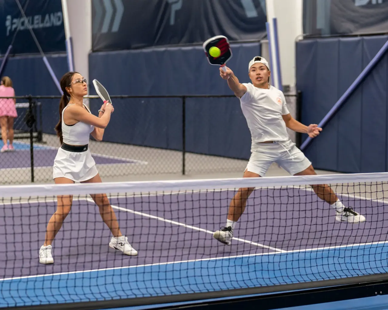 Young mixed-doubles partners in a fast rally at the net