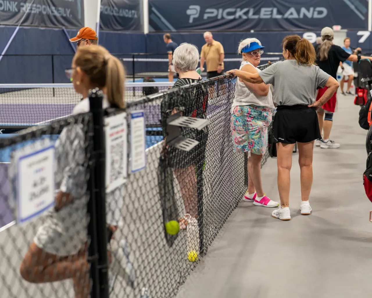 Pickleball players mingling at the net during a social session
