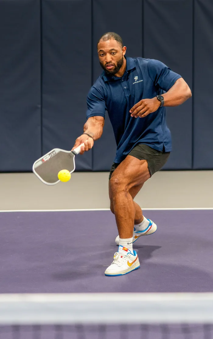 Rico of the Pickleland team driving a forehand on court