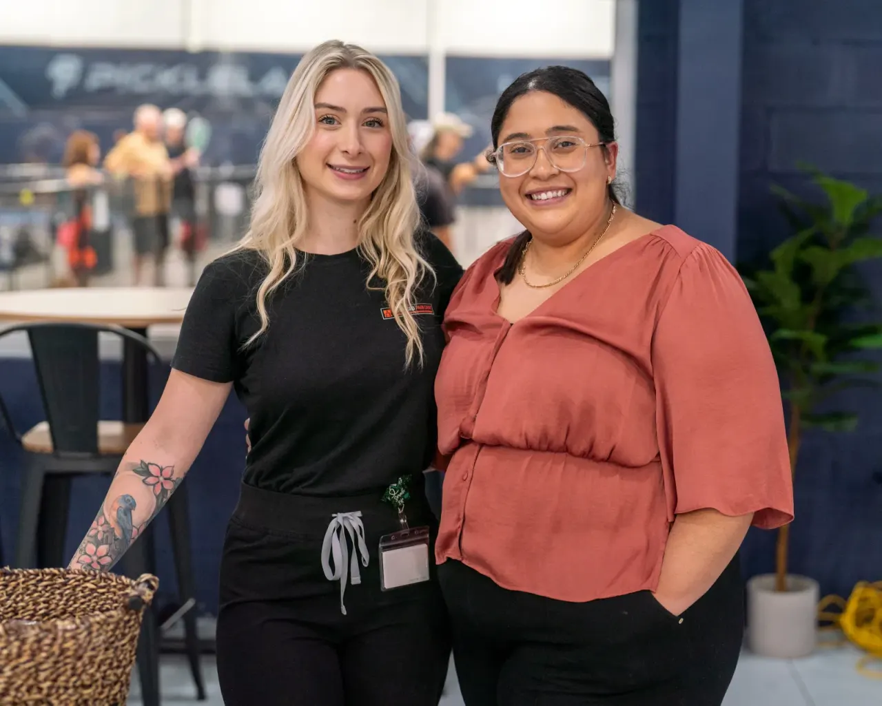 Two women smiling together at a Pickleland event