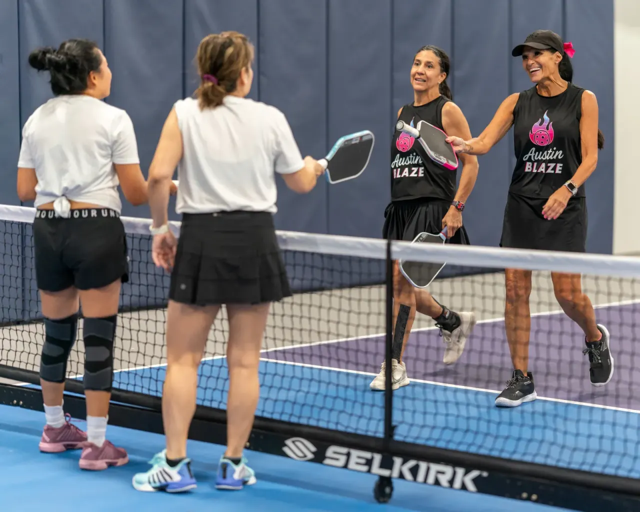 Women's doubles partners playing at the net