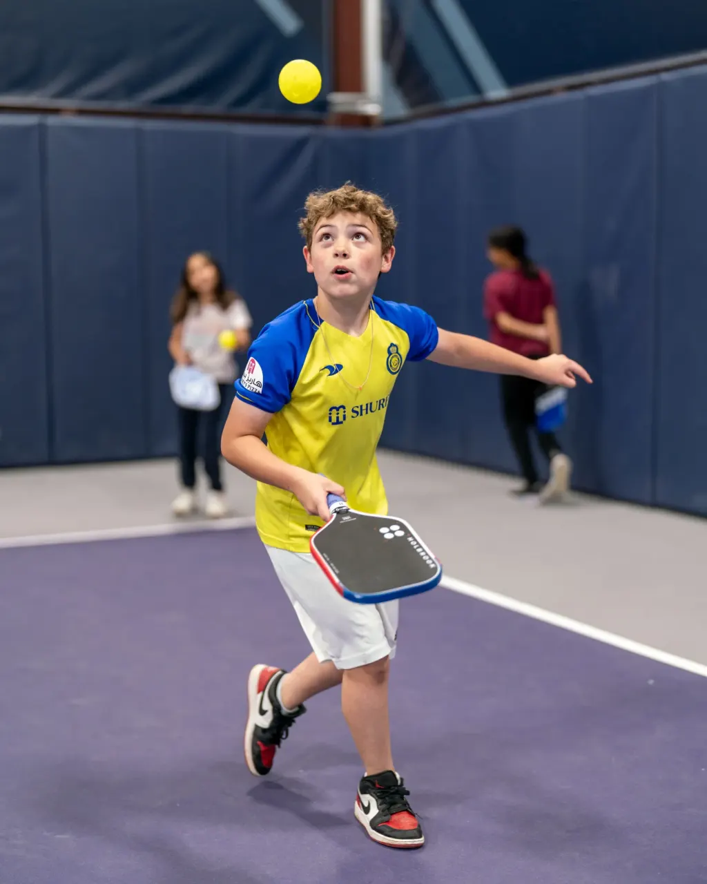 Young boy hits a forehand during a clinic