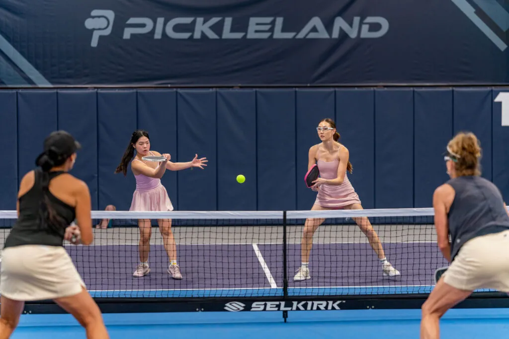 Players rallying on an indoor pickleball court at a climate-controlled Austin-area club