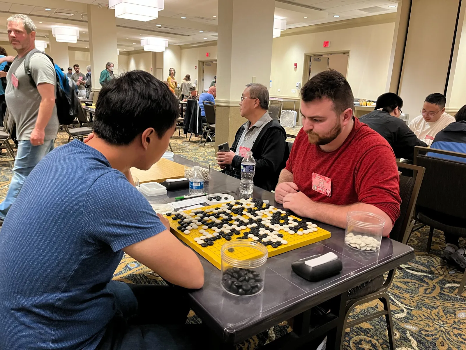 Colleagues gathered around a table during a board game tournament