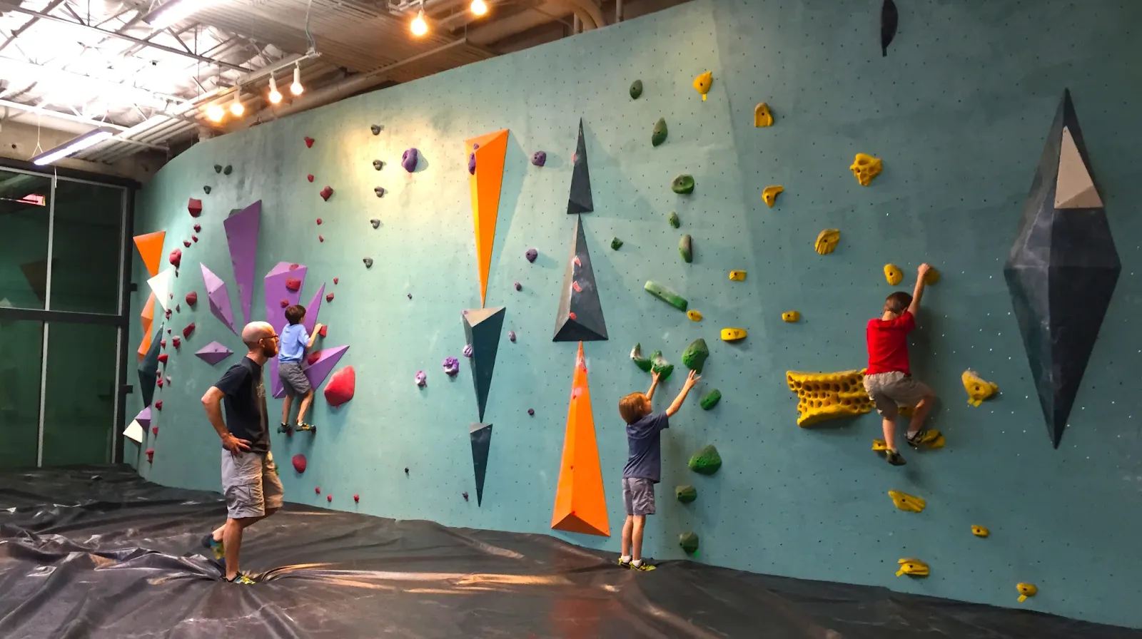 A climber scaling an indoor bouldering wall at the Austin Bouldering Project