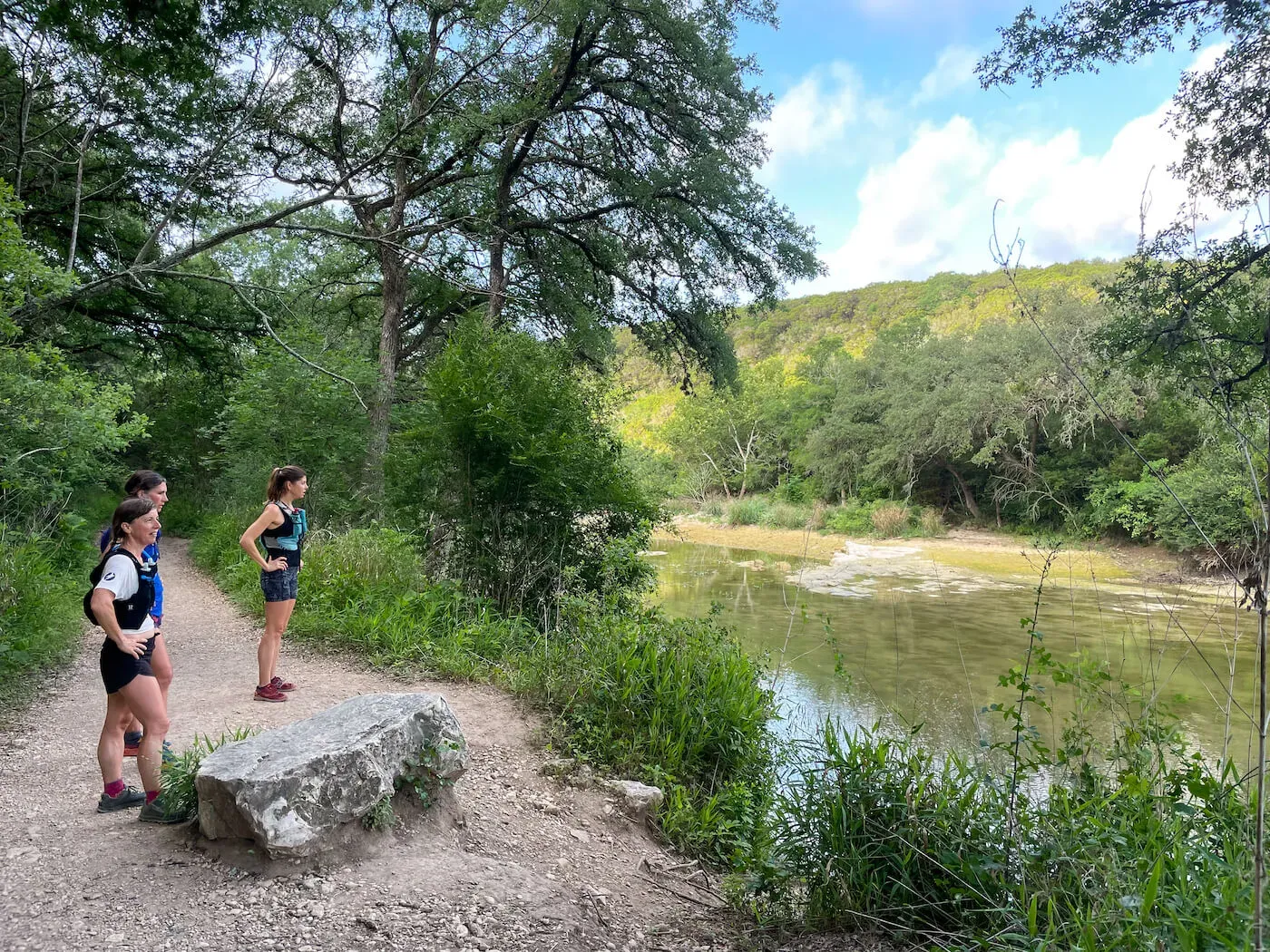 A couple hiking a wooded trail along the creek at Barton Creek Greenbelt in Austin
