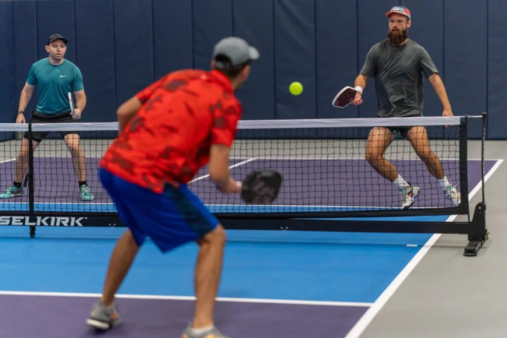 Players competing on indoor courts at a Pickleland pickleball event