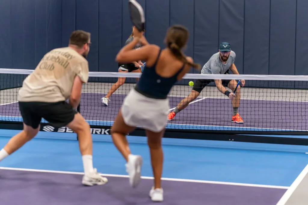 Player setting up a controlled placement shot in a doubles pickleball match