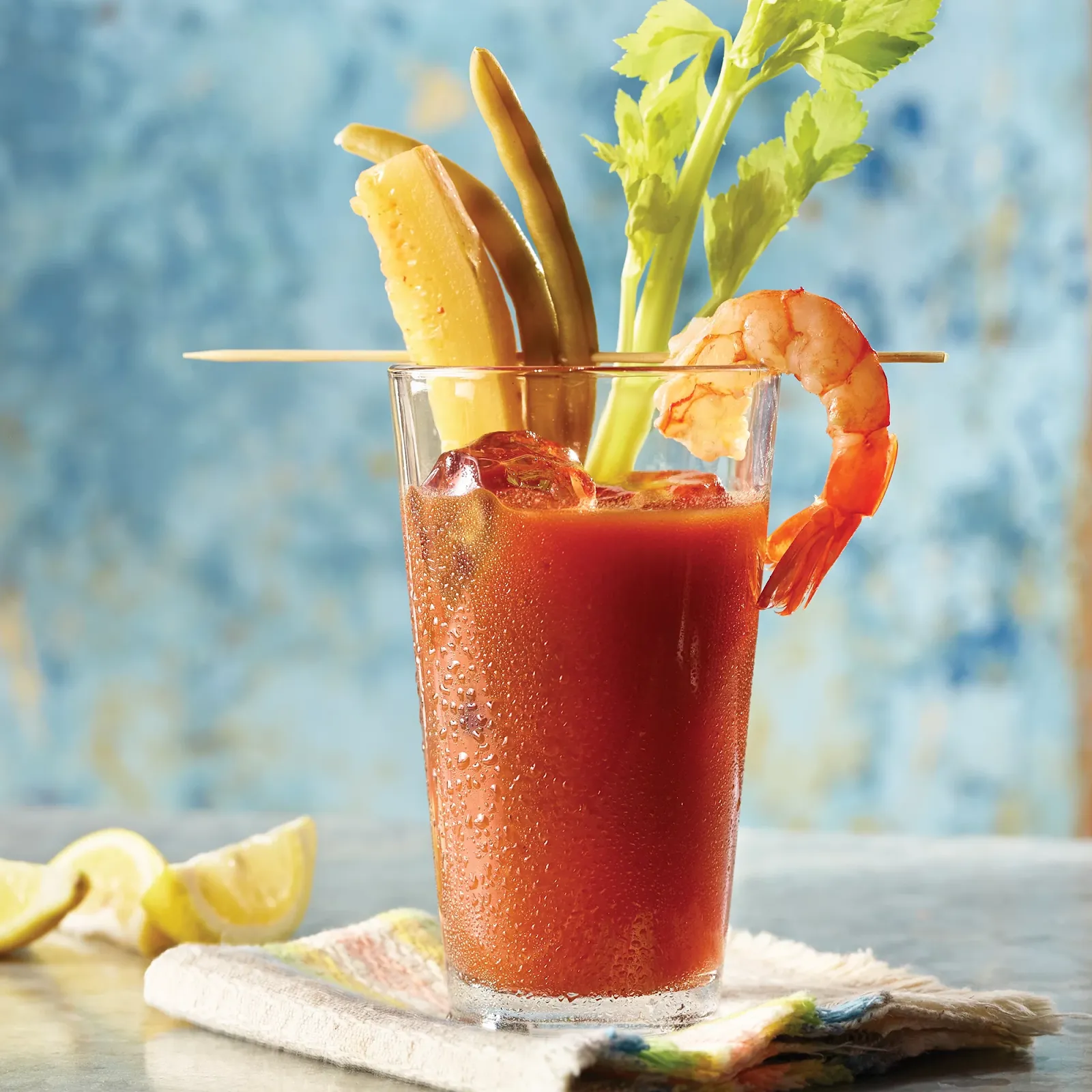 Dill pickle Bloody Mary garnished with a pickle spear and lemon wedge