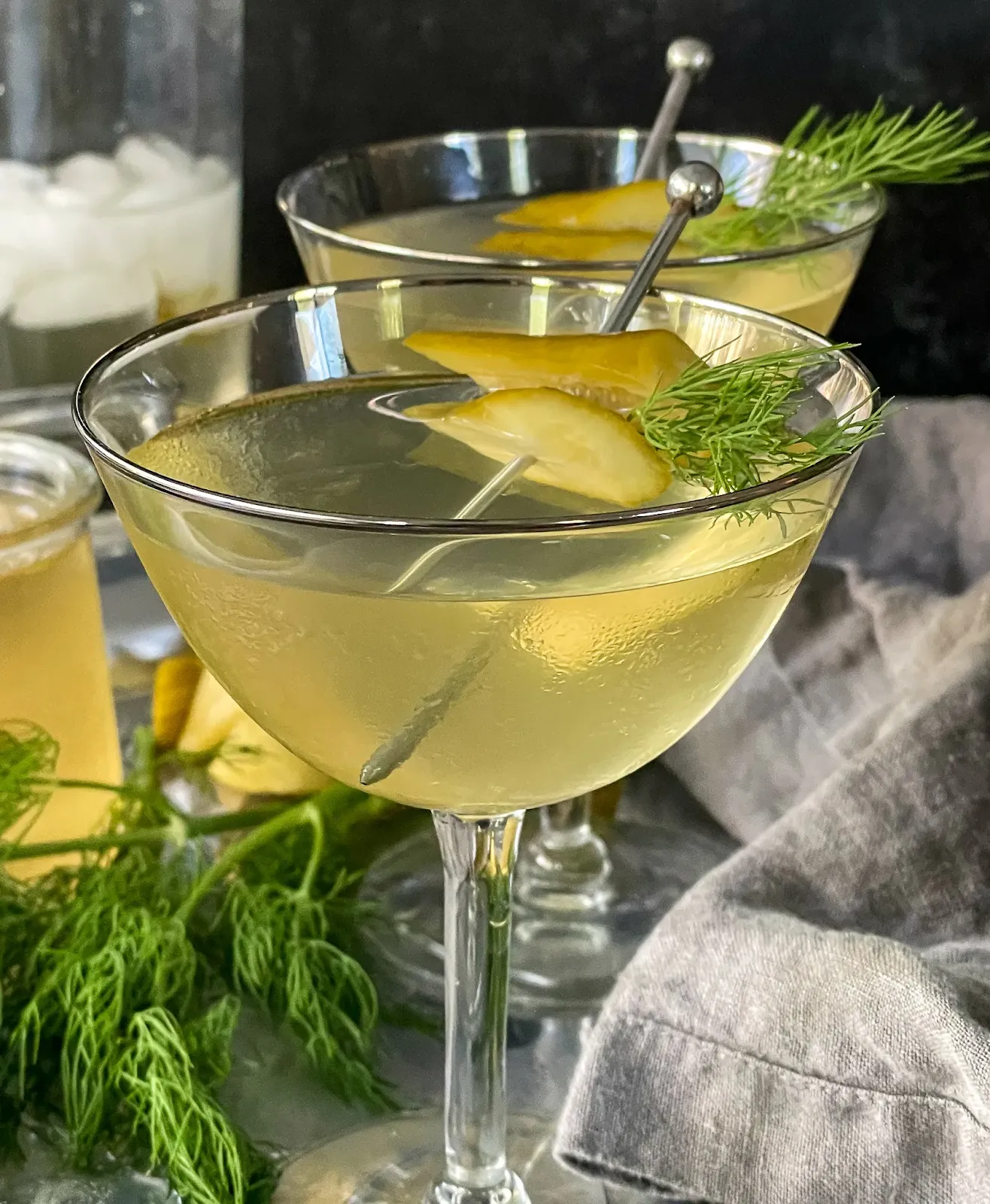 Dill pickle martini garnished with pickle slices in a chilled martini glass