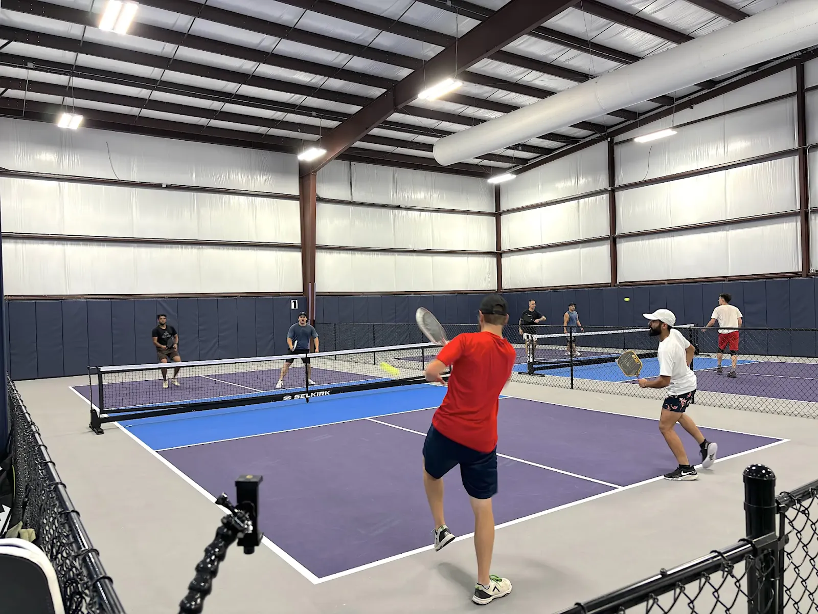 Players enjoying a friendly pickleball game at Pickleland's indoor courts