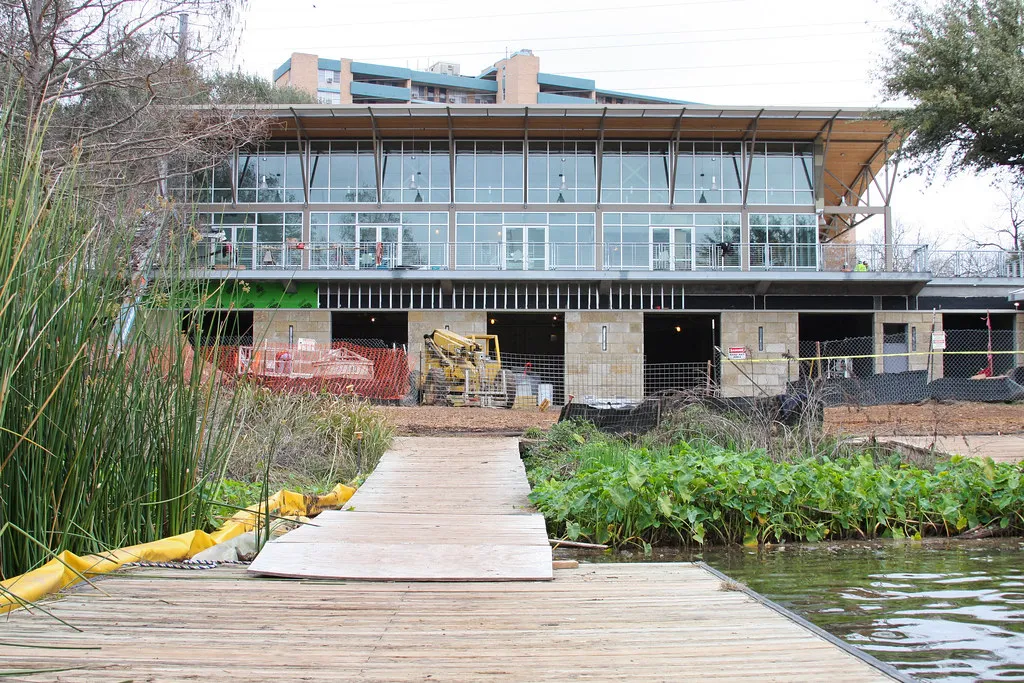 Waller Creek Boathouse on the water with lush green surroundings in Austin