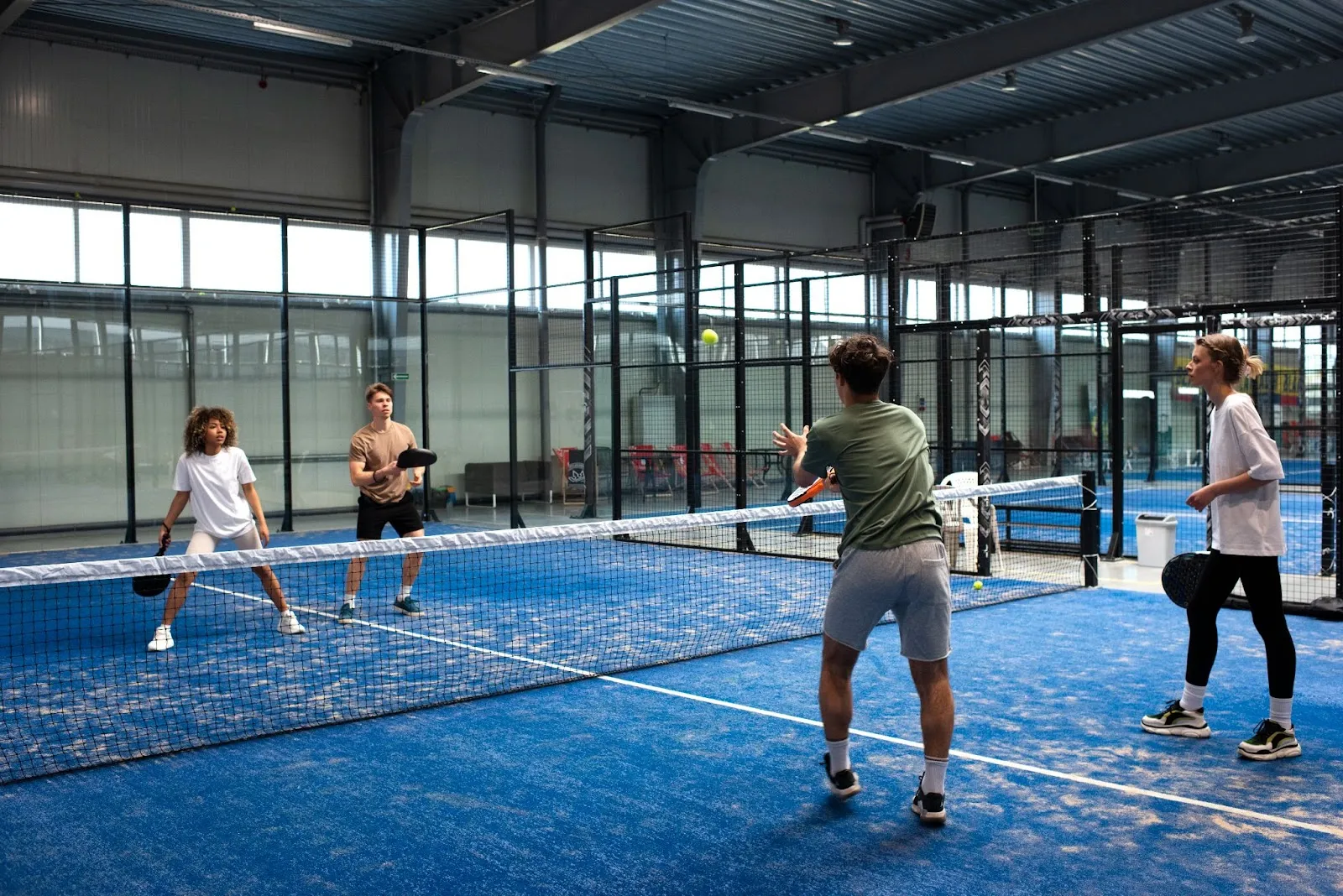 Player jumping past the net post to hit an Erne shot in pickleball