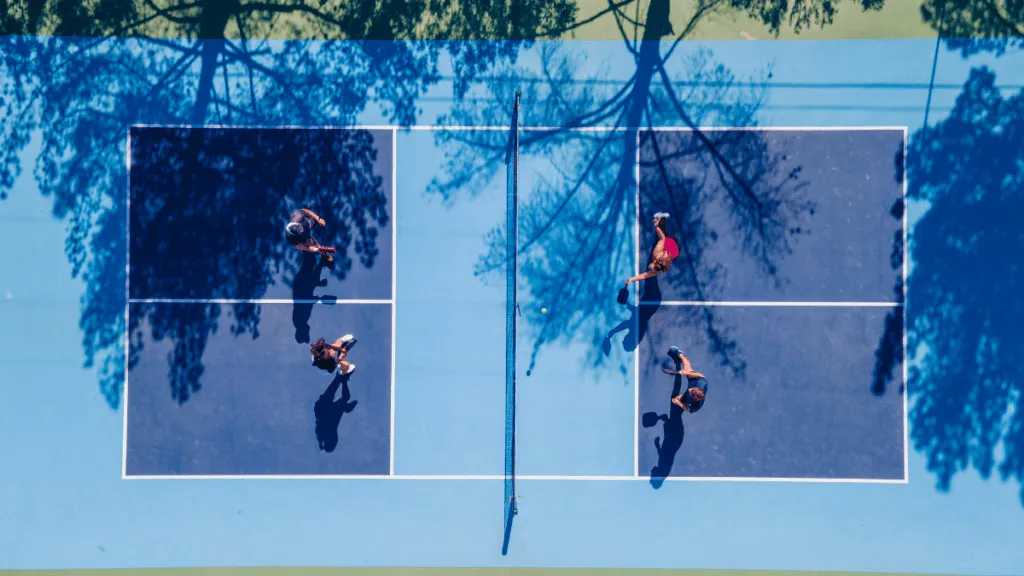 Pickleball players mid-rally during an open play session on an indoor court